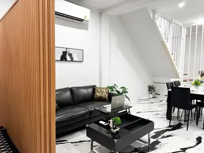 a living room with a black leather couch and a table at Number 31 Bangkok Family in Bangkok