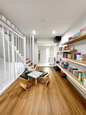 a living room with a table and bookshelves at Number 31 Bangkok Family in Bangkok