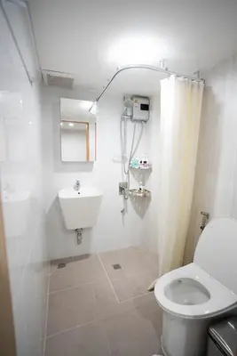 a white bathroom with a toilet and a sink at Number 31 Bangkok Family in Bangkok