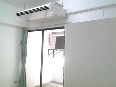 a ceiling fan in a room with a mirror at Sathitsit Mansion in Bangkok