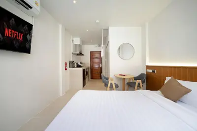 a hotel room with a bed and a kitchen at OH Suites 72 in Bangkok