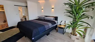 a bedroom with a bed and a potted plant at Stylish New Condo in NANA in Bang Kapi