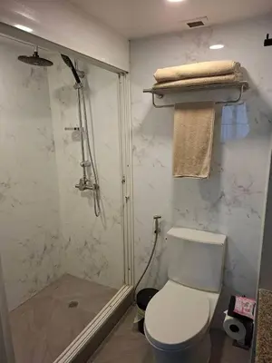 a bathroom with a shower and a toilet and a shower at Stylish New Condo in NANA in Bang Kapi