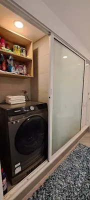 a sliding glass door in a kitchen with a microwave at Stylish New Condo in NANA in Bang Kapi