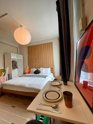 a bedroom with a bed and a table with plates on it at Office 3 in Bangkok