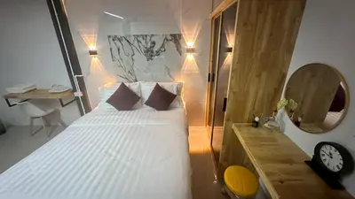 a bedroom with a bed with a clock and a desk at Villa Moon Terrace in Bang Khen