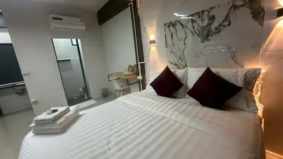 a bedroom with a large white bed with red pillows at Villa Moon Terrace in Bang Khen