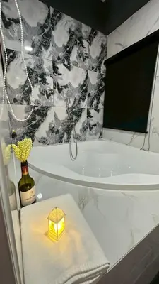 a bathroom with a bath tub and a candle on a towel at Villa Moon Terrace in Bang Khen