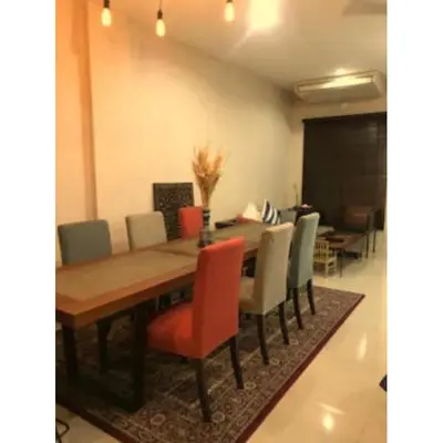 a dining room with a wooden table and chairs at Leon Sukhumvit 62 in Bangkok