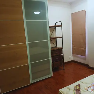 a glass cabinet in a room with a bed at Leon Sukhumvit 62 in Bangkok