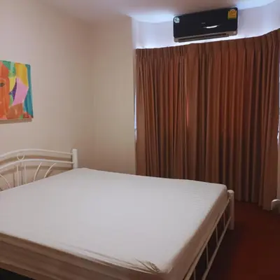 a bedroom with a bed and a television above it at Leon Sukhumvit 62 in Bangkok