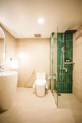 a bathroom with a shower and a toilet and a sink at Palma Hotel in Bangkok