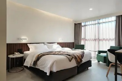 a bedroom with a large bed and a large window at Palma Hotel in Bangkok