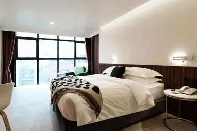 a bedroom with a large bed and a large window at Palma Hotel in Bangkok
