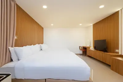 a bedroom with a large white bed and a television at Capitel Sathorn in Yan Nawa