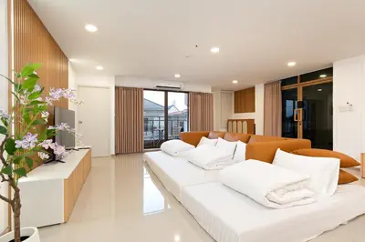 a living room with a white couch and white pillows at Capitel Sathorn in Yan Nawa