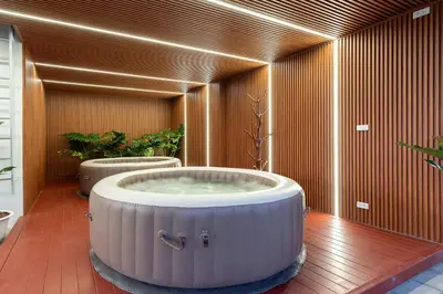 a large bath tub in a room with plants at Capitel Sathorn in Yan Nawa