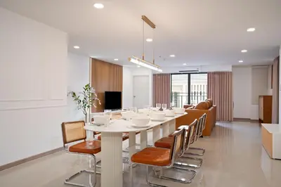 a dining room with a white table and chairs at Capitel Sathorn in Yan Nawa