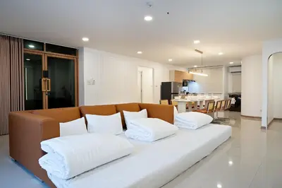 a living room with a couch with pillows on it at Capitel Sathorn in Yan Nawa