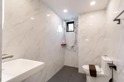 a white bathroom with a sink and a toilet at Capitel Sathorn in Yan Nawa
