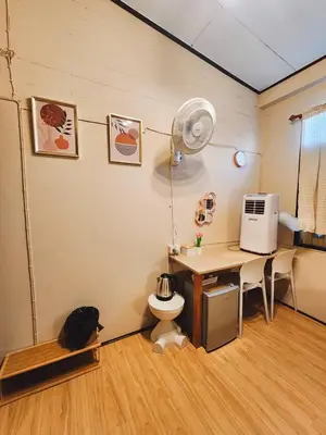 a room with a desk with a fan and a desk with a toilet at 215-Olan Place Free Wi-Fi and Near BTS line in Sathani Bang Khen