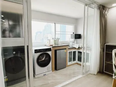 a kitchen with a washer and dryer in a room at Silom Hideaway 27 Floor City View, 4-min to BTS in Bangkok