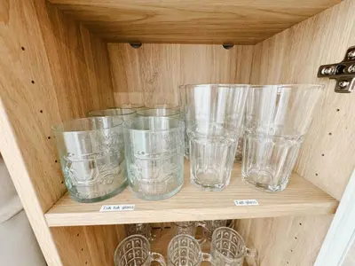 a wooden shelf with clear glasses on it at Silom Hideaway 27 Floor City View, 4-min to BTS in Bangkok