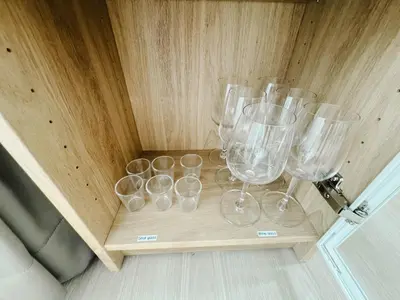 a group of wine glasses on a wooden table at Silom Hideaway 27 Floor City View, 4-min to BTS in Bangkok