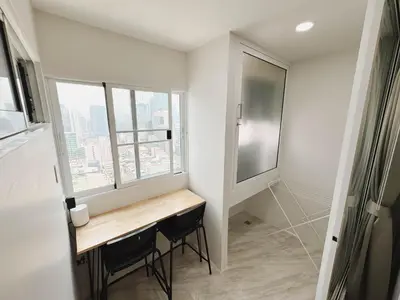 a small bathroom with a desk and a window at Silom Hideaway 27 Floor City View, 4-min to BTS in Bangkok