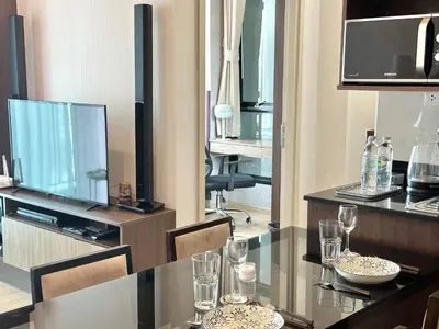 a dining room with a table and a television at 072-Cap-A-R266-F24 in Ban Na Song
