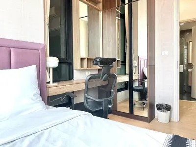 a bedroom with a chair in front of a bed at 072-Cap-A-R266-F24 in Ban Na Song
