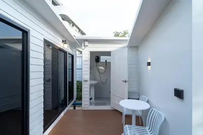 a porch with a white table and chairs on a house at The Lodge Bangkok Poolvilla 2 in Sathani Khlong Tan