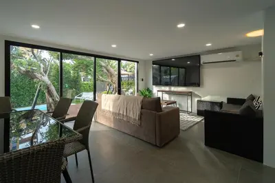 a living room with a couch and a table at The Lodge Bangkok Poolvilla 2 in Sathani Khlong Tan