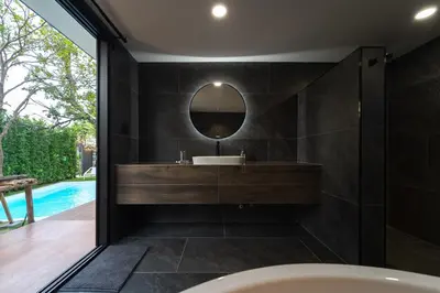 a bathroom with a tub and a sink and a mirror at The Lodge Bangkok Poolvilla 2 in Sathani Khlong Tan