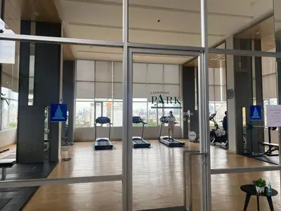 a lobby of a gym with a person on a treadmill at Lumpini Park Vibhavadi-Chatuchak in Bangkok