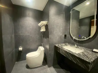 a bathroom with a toilet and a sink and a mirror at Bangkok City Rama 9 Hotel in Bangkok