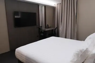 a hotel room with a bed and a flat screen tv at Bangkok City Rama 9 Hotel in Bangkok