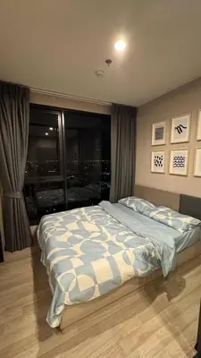 a bedroom with a bed with a view of a city at Bangna Apartment Ideo in Ban Khlong Samrong