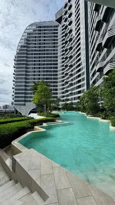 a pool of blue water in front of a building at Bangna Apartment Ideo in Ban Khlong Samrong