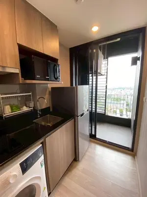 a kitchen with a refrigerator and a sink and a dishwasher at Bangna Apartment Ideo in Ban Khlong Samrong