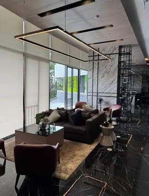 a living room with a couch and a large chandelier at Bangna Apartment Ideo in Ban Khlong Samrong