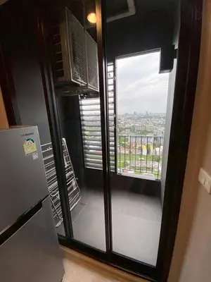 a room with a window with a view of a city at Bangna Apartment Ideo in Ban Khlong Samrong