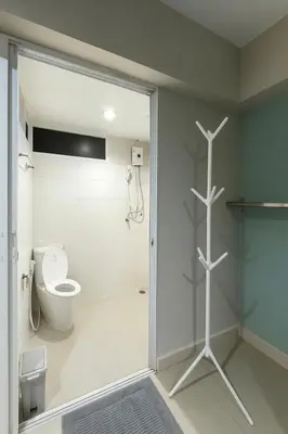 a bathroom with a toilet and a glass shower door at Minimal condo 5 mins to mrt Suthisarn in Bangkok