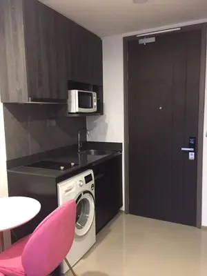a kitchen with a washing machine and a microwave at Ashton Mrt At Bts-Silom Near samyan mitrtown in Bangkok
