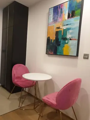 two pink chairs and a table and a painting at Ashton Mrt At Bts-Silom Near samyan mitrtown in Bangkok