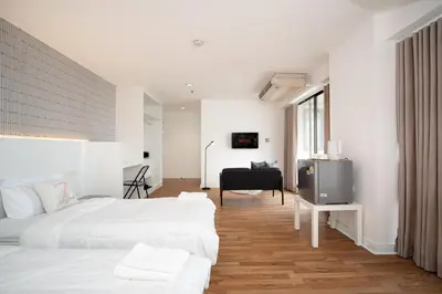 a white bedroom with two beds and a piano at Stylish Twin BR w Ensuite Bath & Relaxing Tub BTB7 in Bangkok