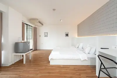 a white bedroom with a bed and a tv at Stylish Twin BR w Ensuite Bath & Relaxing Tub BTB7 in Bangkok