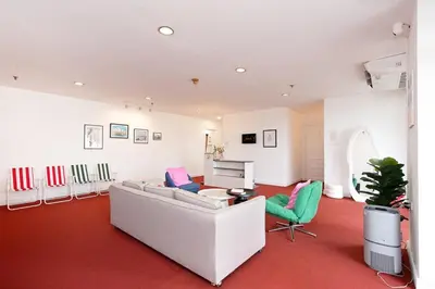 a living room with a white couch and green chairs at Elegant King BR Apt Bathtub, BTS Central BKK BTB8 in Bangkok