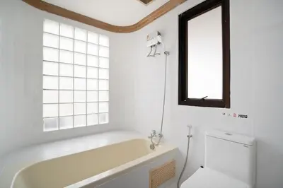 a bathroom with a tub and a toilet and a window at Elegant King BR Apt Bathtub, BTS Central BKK BTB8 in Bangkok