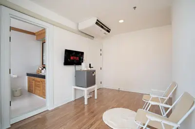 a room with two chairs and a tv in it at Elegant King BR Apt Bathtub, BTS Central BKK BTB8 in Bangkok
